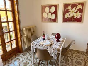 a dining room with a table and chairs with a white tablecloth at Mantula Home By JDvacanze in Manduria