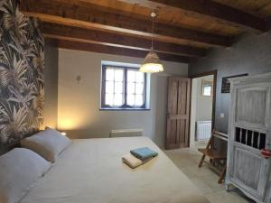 a bedroom with a large bed with two books on it at Gîte Authentique Calme avec Piscine et Jardin Privé - FR-1-616-474 in Sainte-Sabine +11 photos