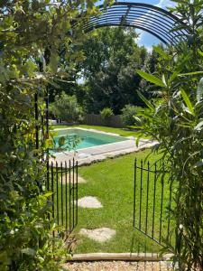 a gate in a garden with a swimming pool at Le Boudoir proche Montignac, Hautefort in Saint-Rabier