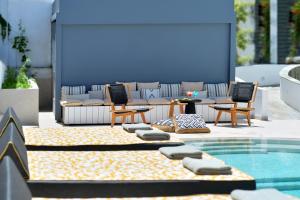斯卡拉Aktaion Beach Boutique Hotel & Spa的带桌椅和游泳池的露台