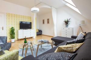 a living room with two couches and a tv at Romantic Balcony Apartment in Old Town in Prague