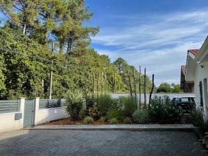 a fence in front of a house with a lake at Villa de Gascogne in Lanton