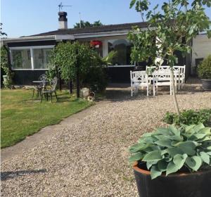 a house with a patio with a table and chairs at Strandhuset in Broager