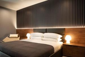 a bedroom with a bed with two lights on it at Black C House Modern w pool spa in Yucca Valley +24 photos