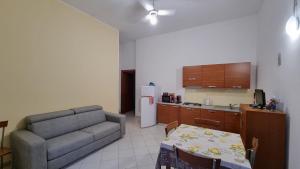 a living room with a couch and a table and a kitchen at La casa di Follonica in Follonica