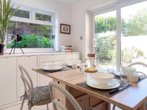 a kitchen with a table with chairs and a window at Atelier Verde - A Comfortable Garden Apartment in Bournemouth