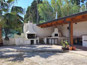 an outdoor kitchen with a table and an oven at Michela's house in Capo Vaticano