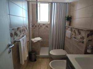 a bathroom with a toilet and a sink and a window at Michela's house in Capo Vaticano