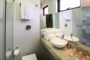 a bathroom with a sink and a mirror at Hotel Santa Cruz in Santa Cruz do Sul +52 photos
