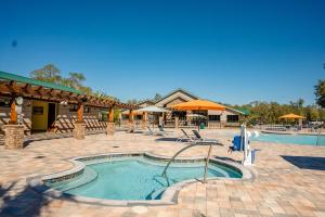 a pool at a resort with chairs and an umbrella at Black Prong Resort in Bronson