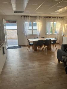 a living room with a dining room table and chairs at Le feuillu Bogny-sur-Meuse in Braux