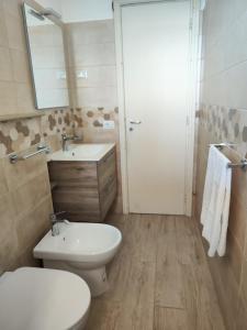 a bathroom with a toilet and a sink and a mirror at Michela's house in Capo Vaticano