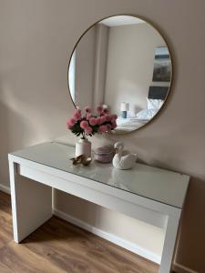 a dressing table with a mirror and flowers on it at Sheffield City Centre - Westhill House Apartments in Sheffield +5 photos