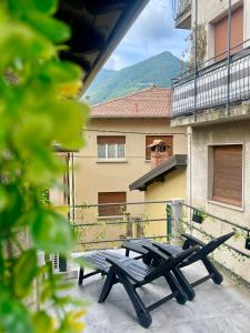 two picnic tables on the balcony of a building at Timco apartment with big terrace, partial lake view and air-conditioner in Torno