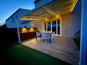 a patio with a table and chairs on a deck at Maison 3 chambres avec jardin et spa in Les Arcs sur Argens +15 photos