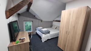 ein Schlafzimmer mit Bett, Fernseher und Schrank in der Unterkunft Old Style in Vratsa + 41 Fotos