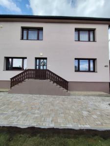 a white house with a staircase and a patio at Apartmán ViVi Pribylina in Pribylina