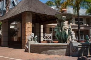 a man standing next to a fountain in front of a building at Summerview Guest Lodge in Johannesburg