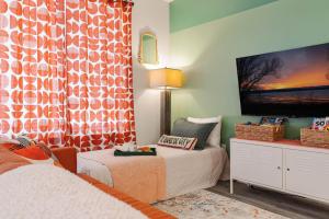 a room with two beds and a tv on the wall at Le Nid Trailside 1BD Close to Beach Downtown in Traverse City