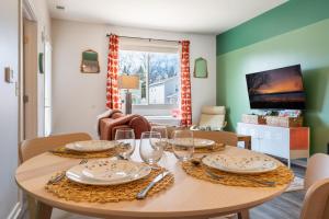 a dining room with a table with plates and wine glasses at Le Nid Trailside 1BD Close to Beach Downtown in Traverse City