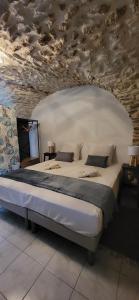 a bedroom with a large bed in a room with a stone ceiling at Les parfums du midi in Saint-Victor-de-Malcap