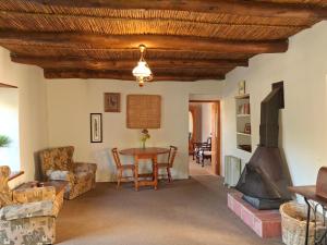 a living room with a table and a fireplace at Schalkenbosch Heritage Cottages in Tulbagh