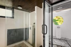 a bathroom with a shower with a glass door at The Sunhouse at Paradise Village in Ban Bang Po +25 photos