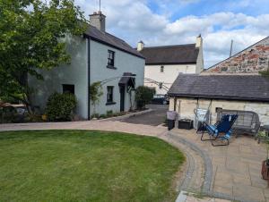 a house with a yard with chairs in front of it at Riverside Cottage in Castledawson
