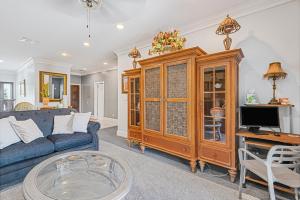 a living room with a blue couch and a tv at 5min Walk from Love Beach A Spacious Home in Nassau in Orange Hill