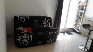 Una maleta negra sentada en una habitación con escritura. en Appart Le Massillon Arenes Centre, en Nimes