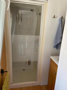 a shower with a glass door in a bathroom at mobil home 3 chambres in Pataias +5 photos