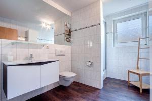 Baño blanco con aseo y lavamanos en Ostseepark Waterfront Karavelle Wohnung 3.0 en Heringsdorf