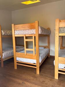 a room with three bunk beds in a room at hostel arcoiris urubamba in Urubamba