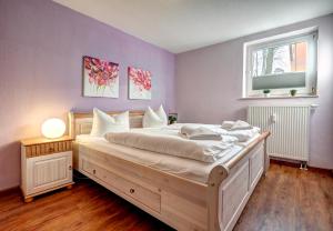 1 dormitorio con 1 cama blanca grande y ventana en Ostseepark Waterfront Karavelle Wohnung 3.0 en Heringsdorf