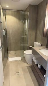 a bathroom with a shower and a toilet and a sink at LVL43 Queens Wharf 1BR Apartment in Brisbane