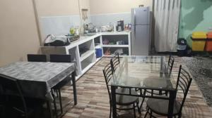 una cucina con tavolo, sedie e frigorifero di Cabini Taz a Talamanca