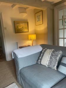 ein blaues Sofa im Wohnzimmer mit Lampe in der Unterkunft Cosy Cottage in Kings Sutton + 21 Fotos