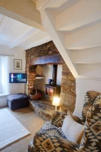 ein Wohnzimmer mit einem Sofa und einem Steinkamin in der Unterkunft Cosy Cottage in Kings Sutton