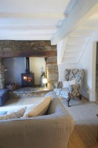 ein Wohnzimmer mit Couch und Kamin in der Unterkunft Cosy Cottage in Kings Sutton
