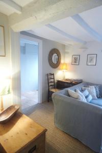 ein Wohnzimmer mit Sofa und Tisch in der Unterkunft Cosy Cottage in Kings Sutton