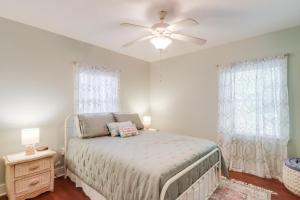 a bedroom with a bed and a ceiling fan at The Little Sandy Flamingo in Gulfport
