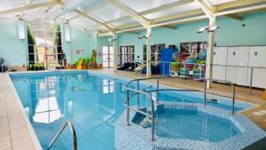 a large swimming pool with blue walls and ceilings at Be Our Guest in Cresswell
