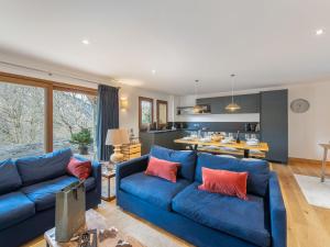 un salon avec des canapés bleus et une cuisine dans l'établissement Charmant appart avec terrasse, parking, WIFI - FR-1-452-390, à Saint-Martin-de-Belleville