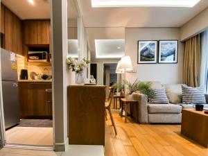 a living room with a couch and a kitchen at Exquisite Modern 1BR - Ultra Fast Wifi - BTS Thong Lo in Bangkok