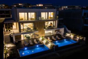 an apartment building with a swimming pool at night at Swellnest in Ericeira