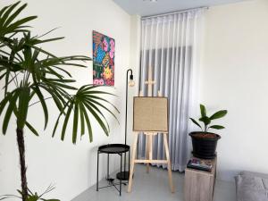 a living room with a plant and a easel at Samui Retreat w Garden Seaview in Ban Nong Chaeng