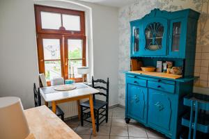 a kitchen with a blue cabinet and a table at Wunderschöne historische 3 Raum Wohnung in Görlitz