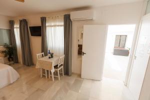 Zimmer mit einem Tisch, einem Tisch und einer Tür in der Unterkunft El ático de Osario 5 con terraza - Great location in Córdoba