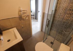 ein Badezimmer mit Dusche, Toilette und Waschbecken in der Unterkunft El ático de Osario 5 con terraza - Great location in Córdoba + 44 Fotos