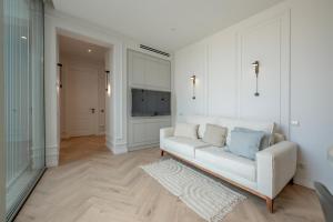 Una sala de estar con un sofá blanco y un televisor. en Metekhi Elegance-Classic Charm in Tbilisi's Heart, en Tiflis